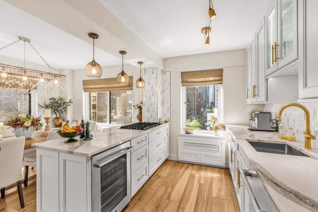 249 East 48th Street, Unit 10B Manhattan, NY 10017 - Photo 6 of 18 a kitchen with a stove a sink and a refrigerator