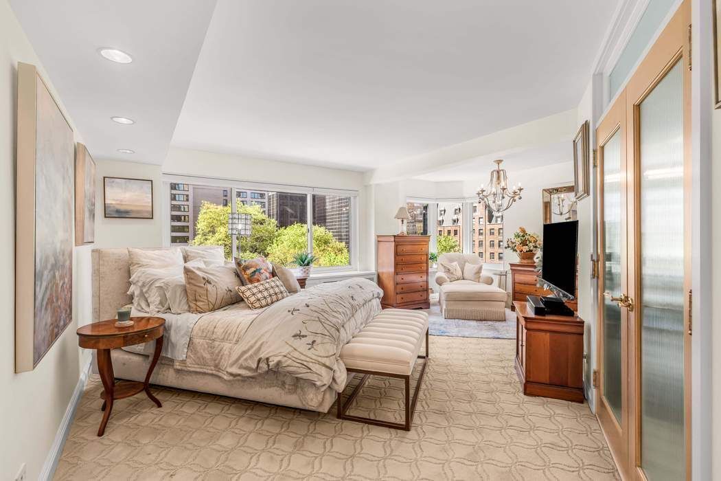 249 East 48th Street, Unit 10B Manhattan, NY 10017 - Photo 8 of 18 a bedroom with furniture and a large window