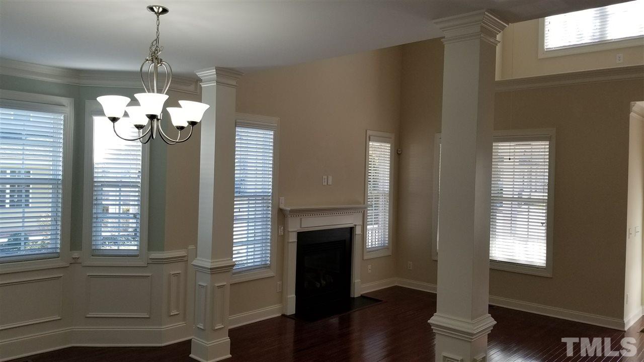 642 Democracy Street Raleigh, NC 27603 - Photo 23 of 25 a dining room with wooden floor fireplace and windows