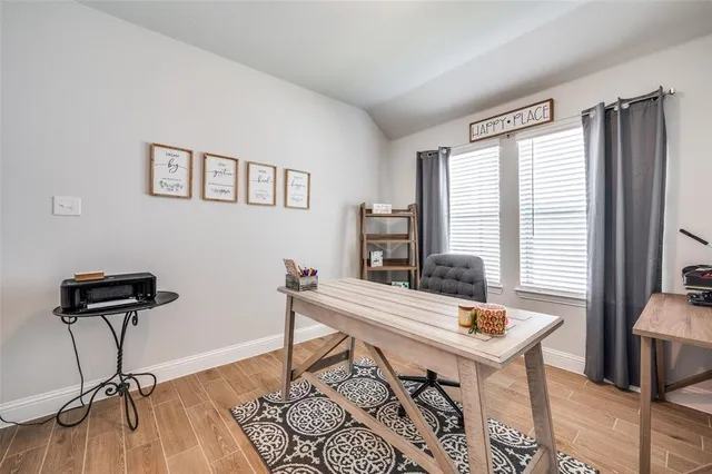 a view of a workspace with furniture and a window
