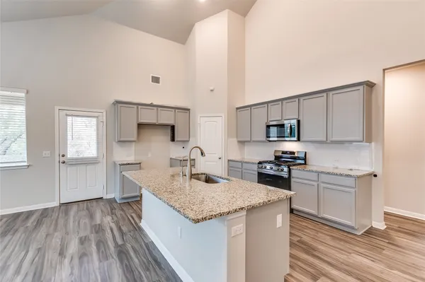 a kitchen with a sink stove and cabinets