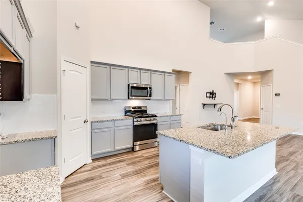 a kitchen with stainless steel appliances granite countertop a sink dishwasher stove top oven and refrigerator