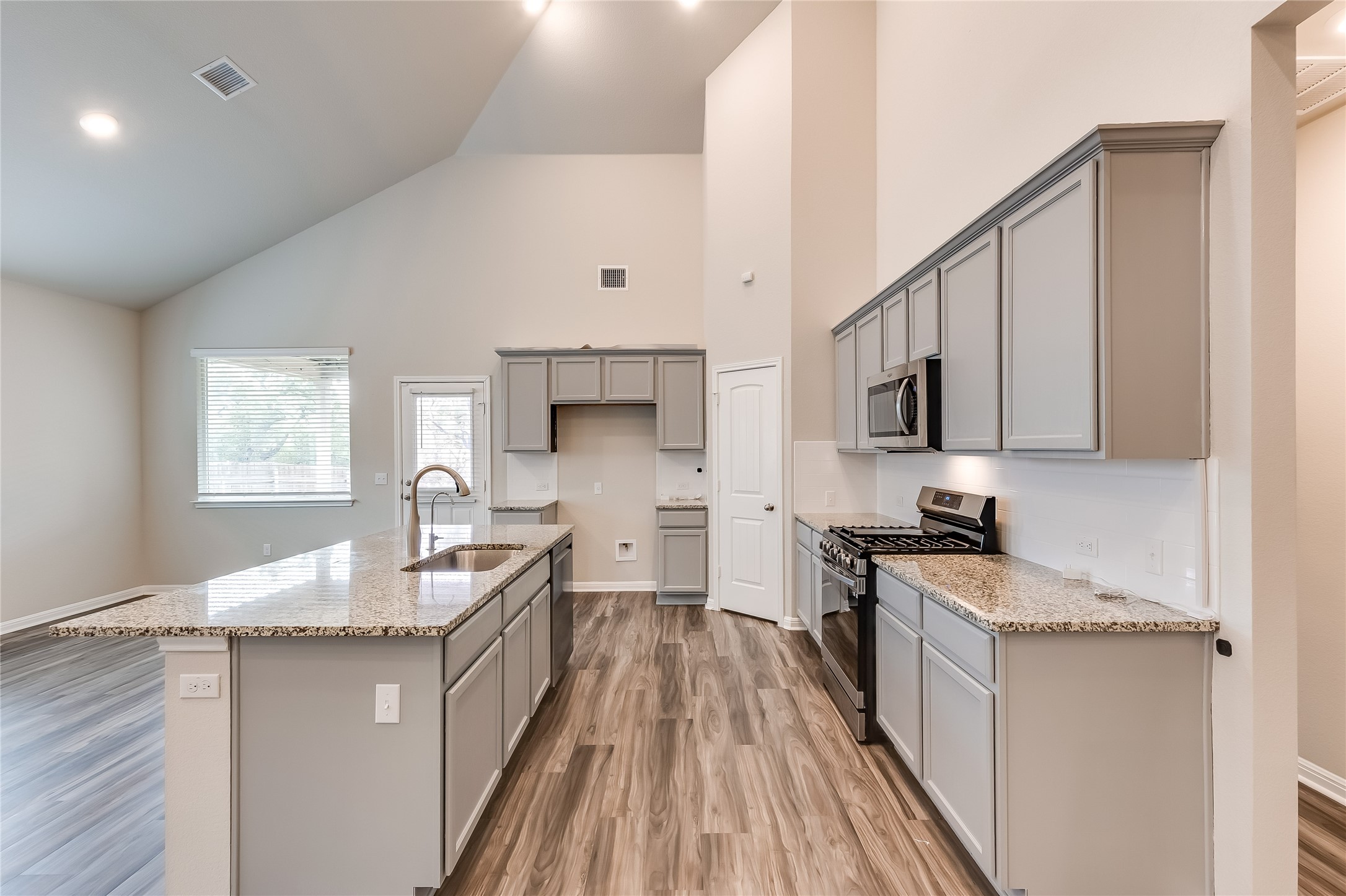312 Empress Tree Drive Leander, TX 78641 - Photo 13 of 35 a kitchen with stainless steel appliances granite countertop a sink stove and wooden cabinets