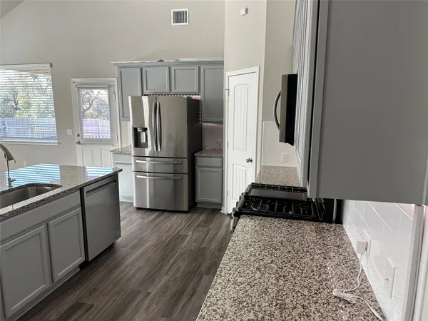 a kitchen with a refrigerator a stove a microwave and cabinets