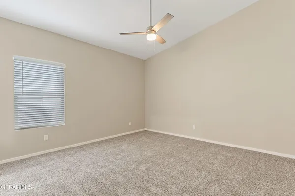 an empty room with a window and a fan