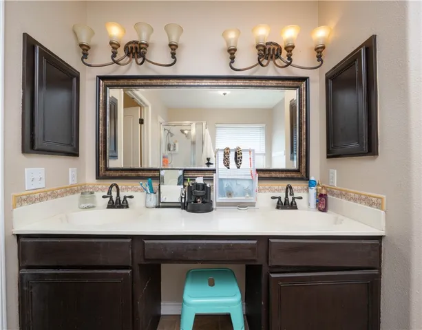 a en suite bathroom with a sink double vanity granite tub and shower