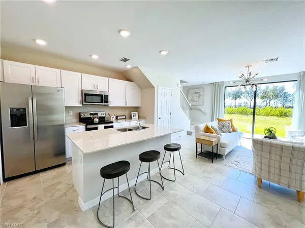 a kitchen with stainless steel appliances a table and chairs in it