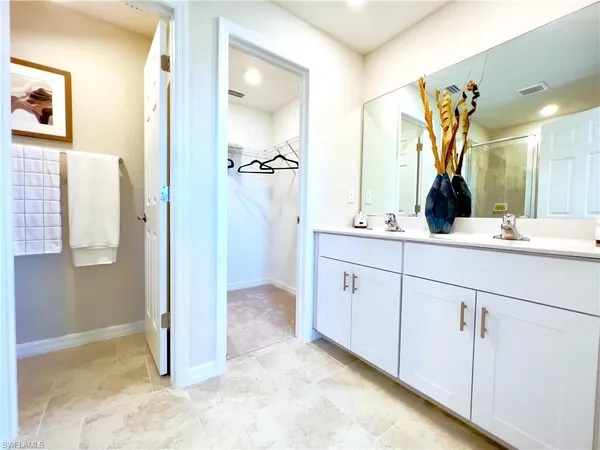 a bathroom with a double vanity sink mirror and shower
