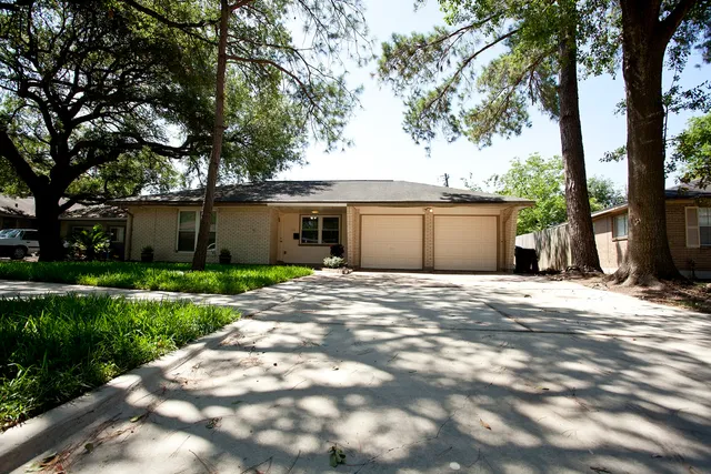a view of a house with a tree in front of it