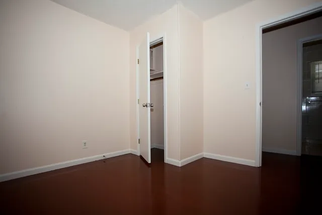 an empty room with wooden floor and closet