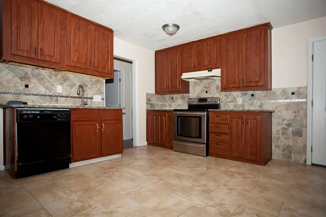 a kitchen with stainless steel appliances granite countertop a stove cabinets and refrigerator