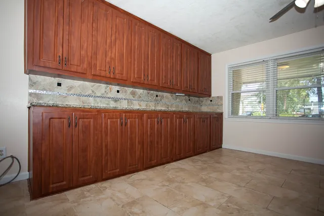 a view of kitchen with granite countertop wooden cabinets