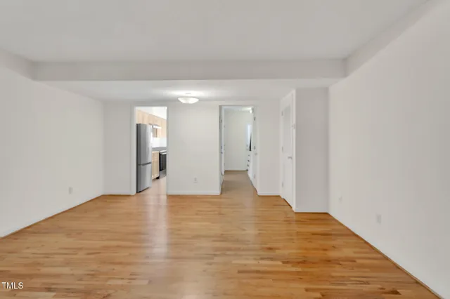 a view of empty room with wooden floor