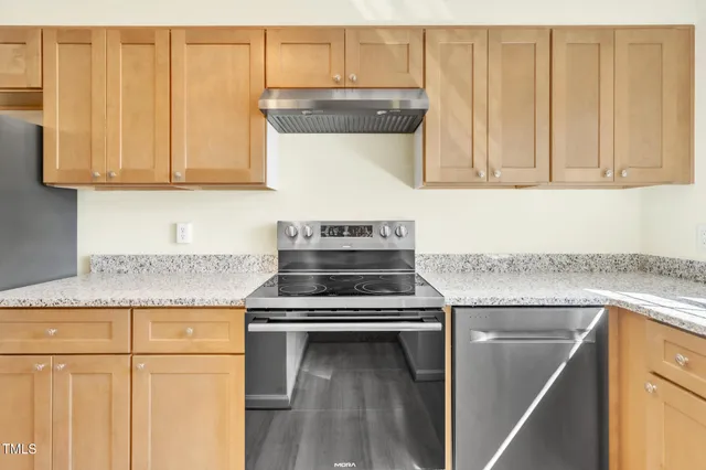 a kitchen with granite countertop a stove a sink and dishwasher