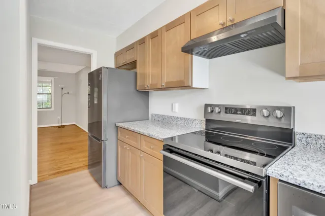 a kitchen with stainless steel appliances granite countertop a refrigerator and a stove