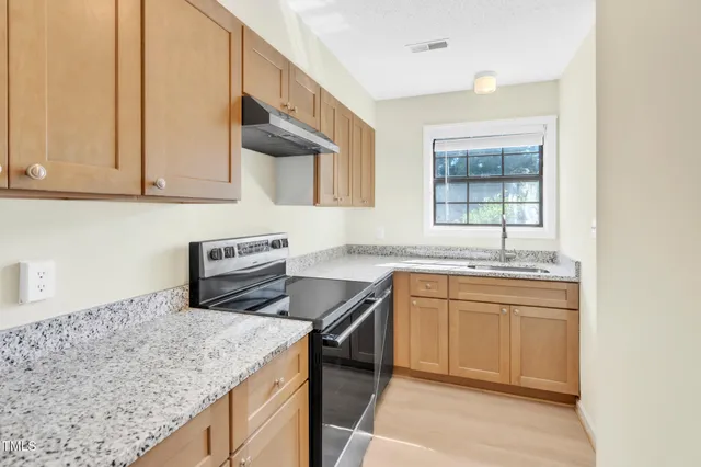 a kitchen with a sink stove and cabinets