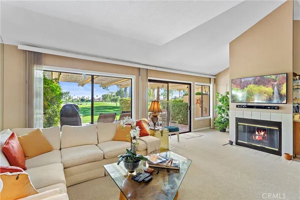 a living room with furniture a floor to ceiling window and a fireplace