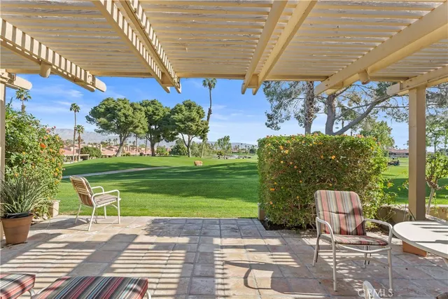 a view of a chairs and table in the backyard