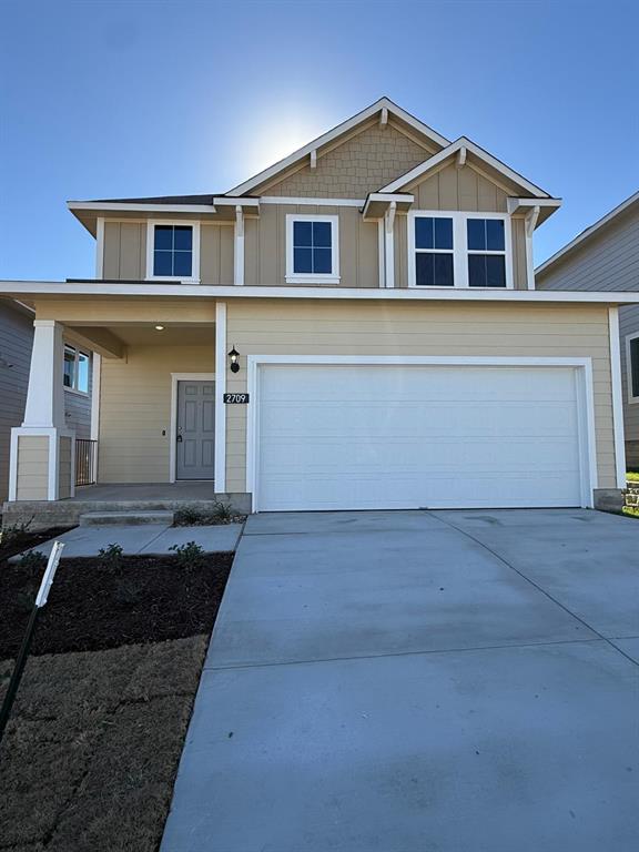 2709 Towy Road Manor, TX 78653 - Photo 1 of 1 View of front of property featuring concrete driveway, a porch, board and batten siding, and a garage