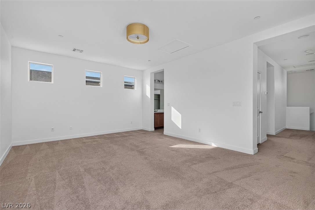 1100 East Sunset Road Henderson, NV 89011 - Photo 33 of 58 A spacious room with soft carpeting and three windows for natural illumination, perfect for adaptable living.