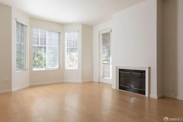 an empty room with windows and fireplace
