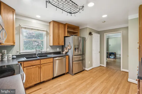 a kitchen with granite countertop a refrigerator and cabinets
