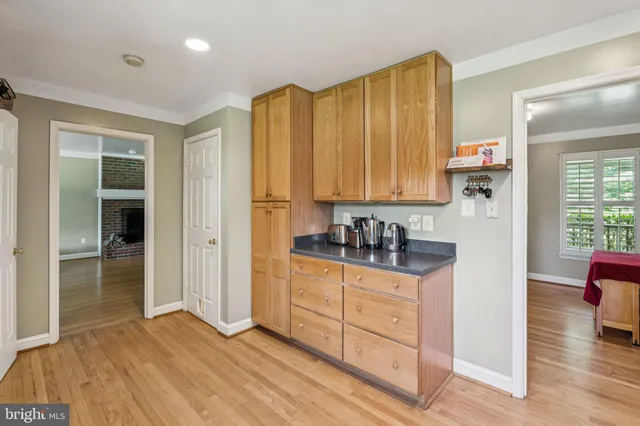 an empty room with wooden floor fireplace and windows