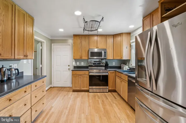 a kitchen with granite countertop a refrigerator stove top oven and sink