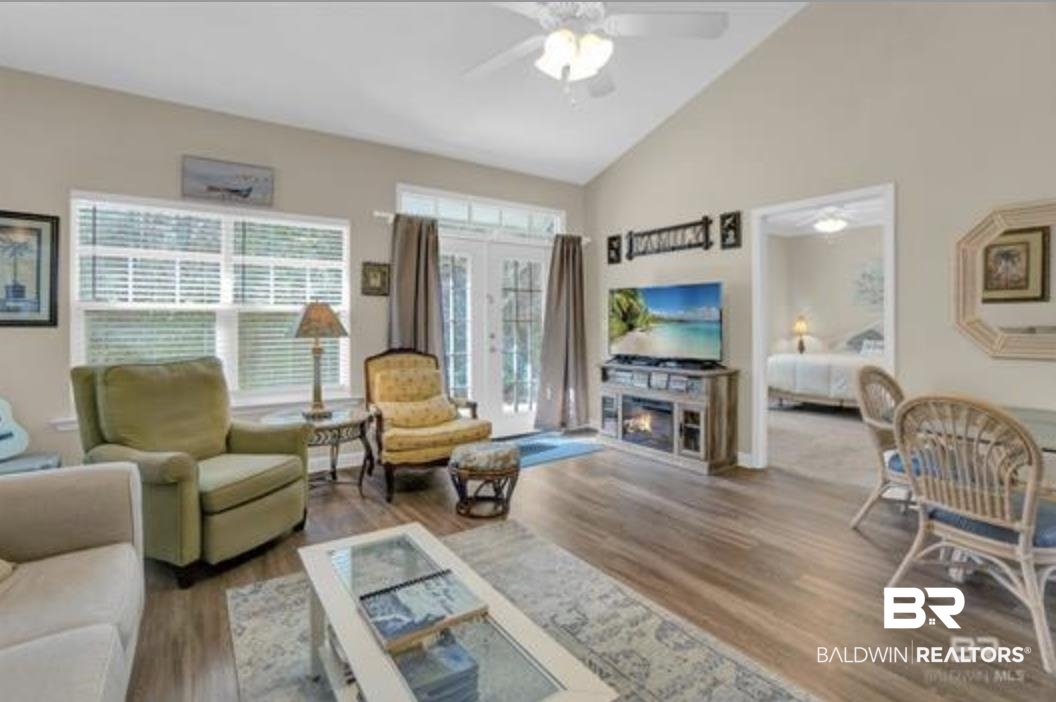 430 West Fort Morgan Road Gulf Shores, AL 36542 - Photo 8 of 27 Living area featuring vaulted ceilings, wood-finish flooring, and light-toned wall paint