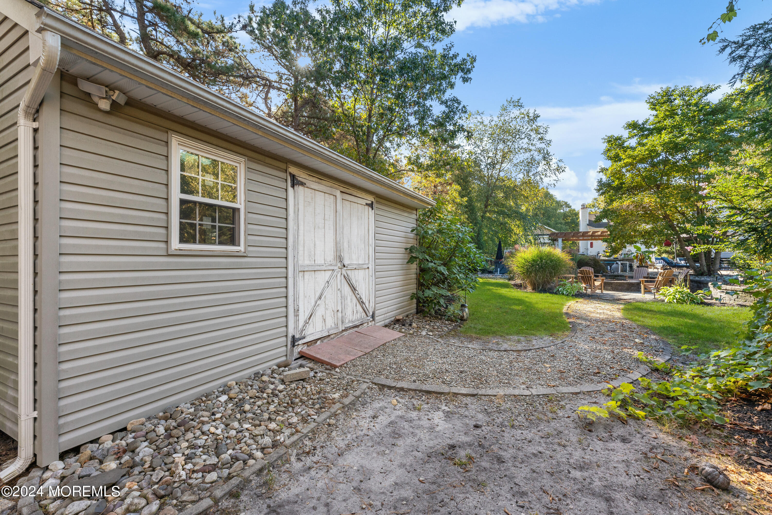 159 Arnold Boulevard Howell, NJ 07731 - Photo 59 of 60 a backyard of a house with plants and outdoor seating