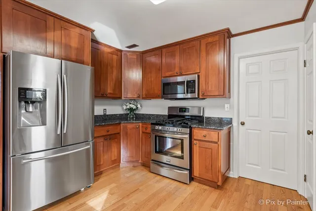 a kitchen with stainless steel appliances granite countertop a refrigerator stove and microwave
