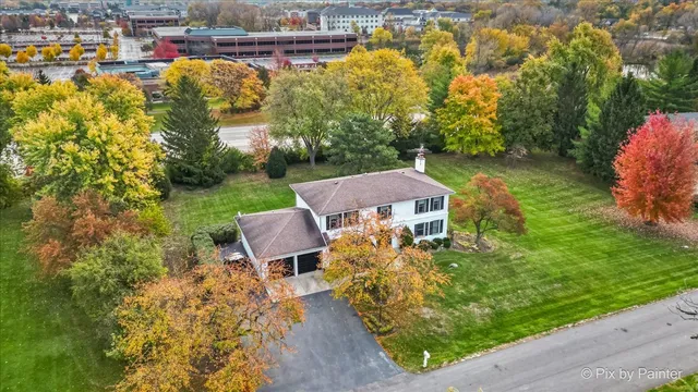 an aerial view of a house with a garden and lake view