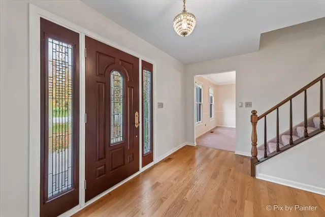 a view of hallway with a door and wooden floor
