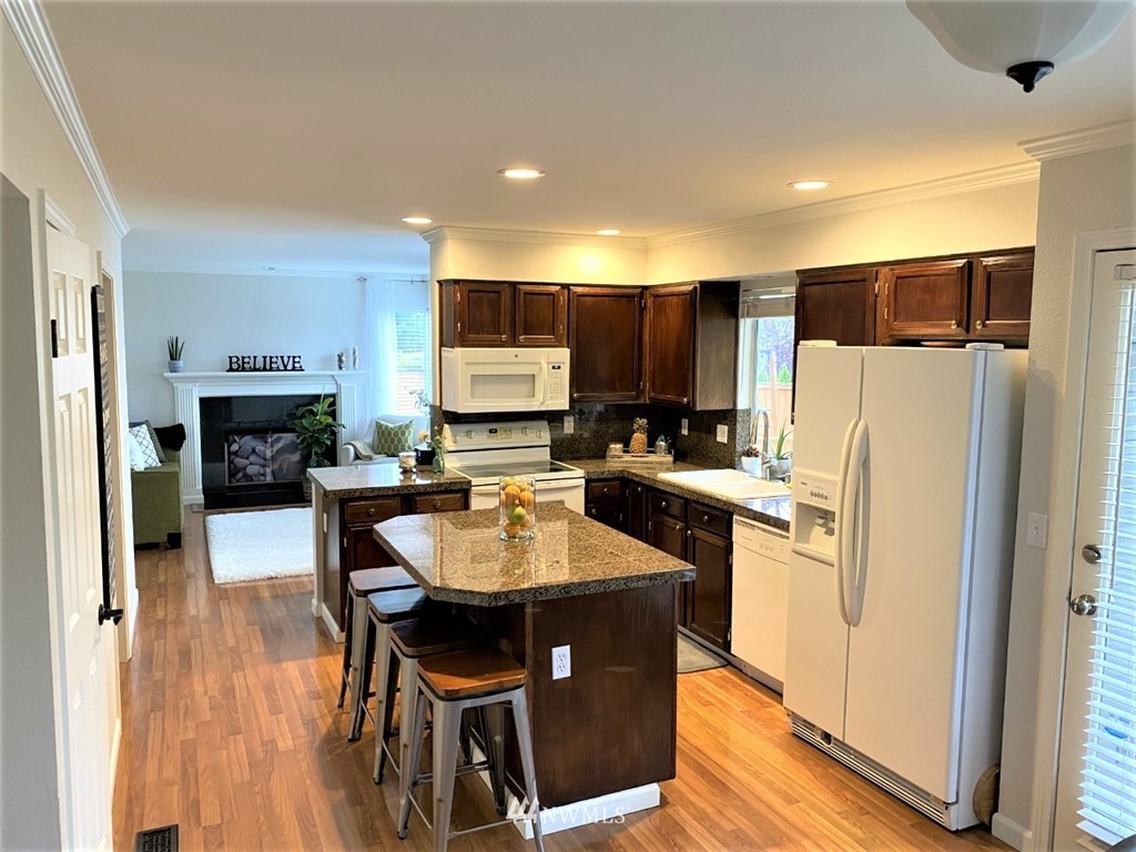 35127 11th Place Southwest Federal Way, WA 98023 - Photo 7 of 31 a kitchen with a refrigerator a stove a sink a dining table and chairs
