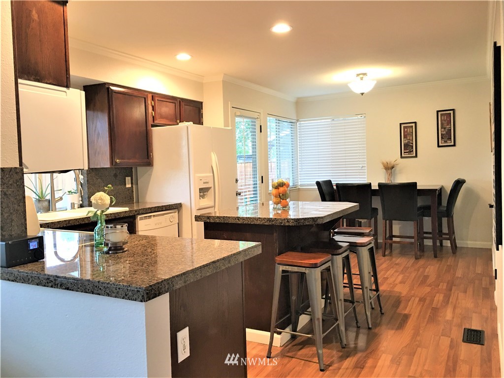 35127 11th Place Southwest Federal Way, WA 98023 - Photo 8 of 31 a kitchen with granite countertop a table chairs stove and kitchen island