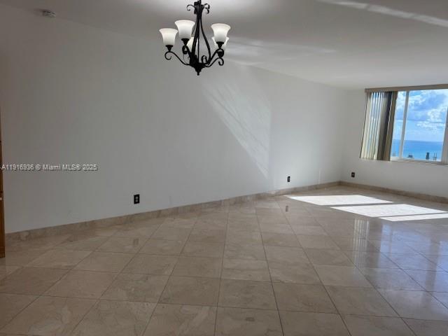 5401 Collins Avenue, Unit 1512 Miami Beach, FL 33140 - Photo 21 of 40 en empty room with chandelier fan and windows