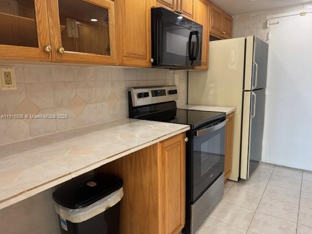 5401 Collins Avenue, Unit 1512 Miami Beach, FL 33140 - Photo 23 of 40 a kitchen with a refrigerator and a stove top oven