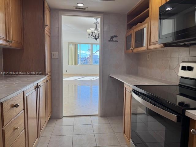 5401 Collins Avenue, Unit 1512 Miami Beach, FL 33140 - Photo 25 of 40 a kitchen that has a sink a stove and cabinets
