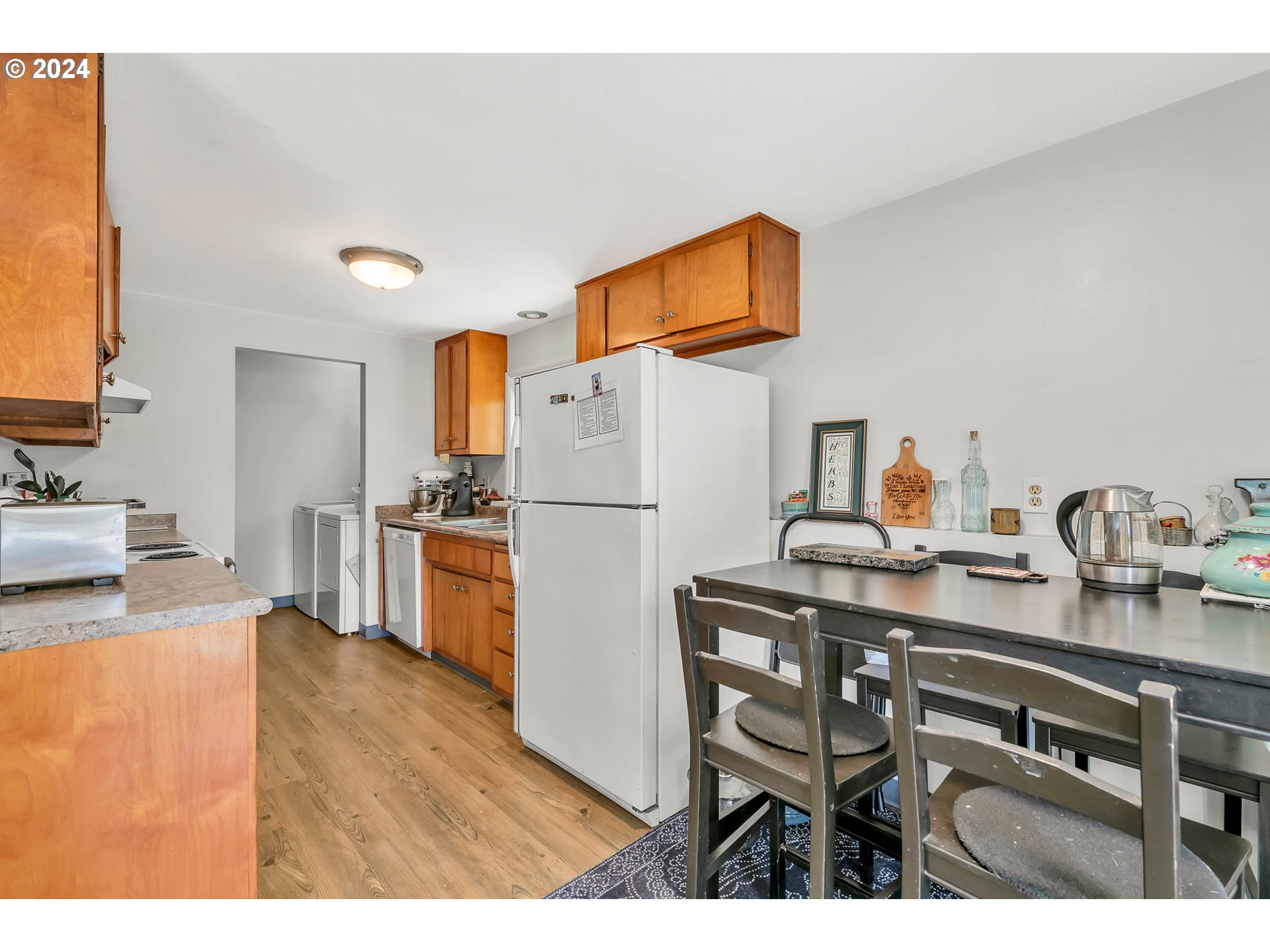 5000 Whiteaker Street Eugene, OR 97405 - Photo 6 of 18 a kitchen with a table chairs refrigerator and a sink
