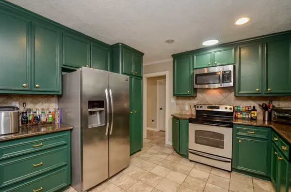 a kitchen with granite countertop a refrigerator and a sink
