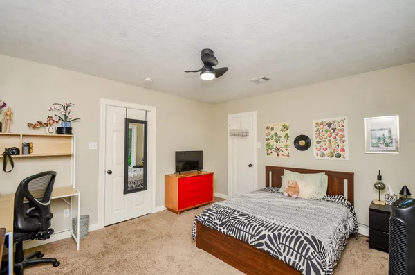 a bedroom with a bed and ceiling fan