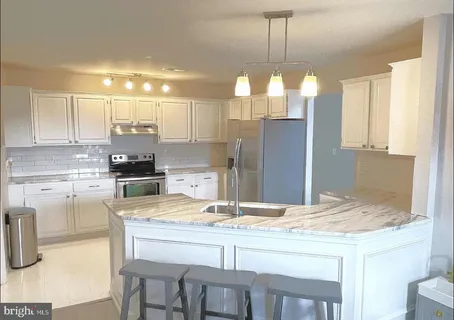 a kitchen with kitchen island granite countertop a table and chairs in it