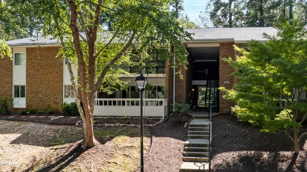 a front view of a house with a tree