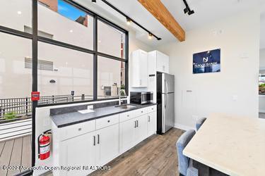 28 Riverside Avenue, Unit 2H Red Bank, NJ 07701 - Photo 25 of 36 a kitchen with a sink and a refrigerator