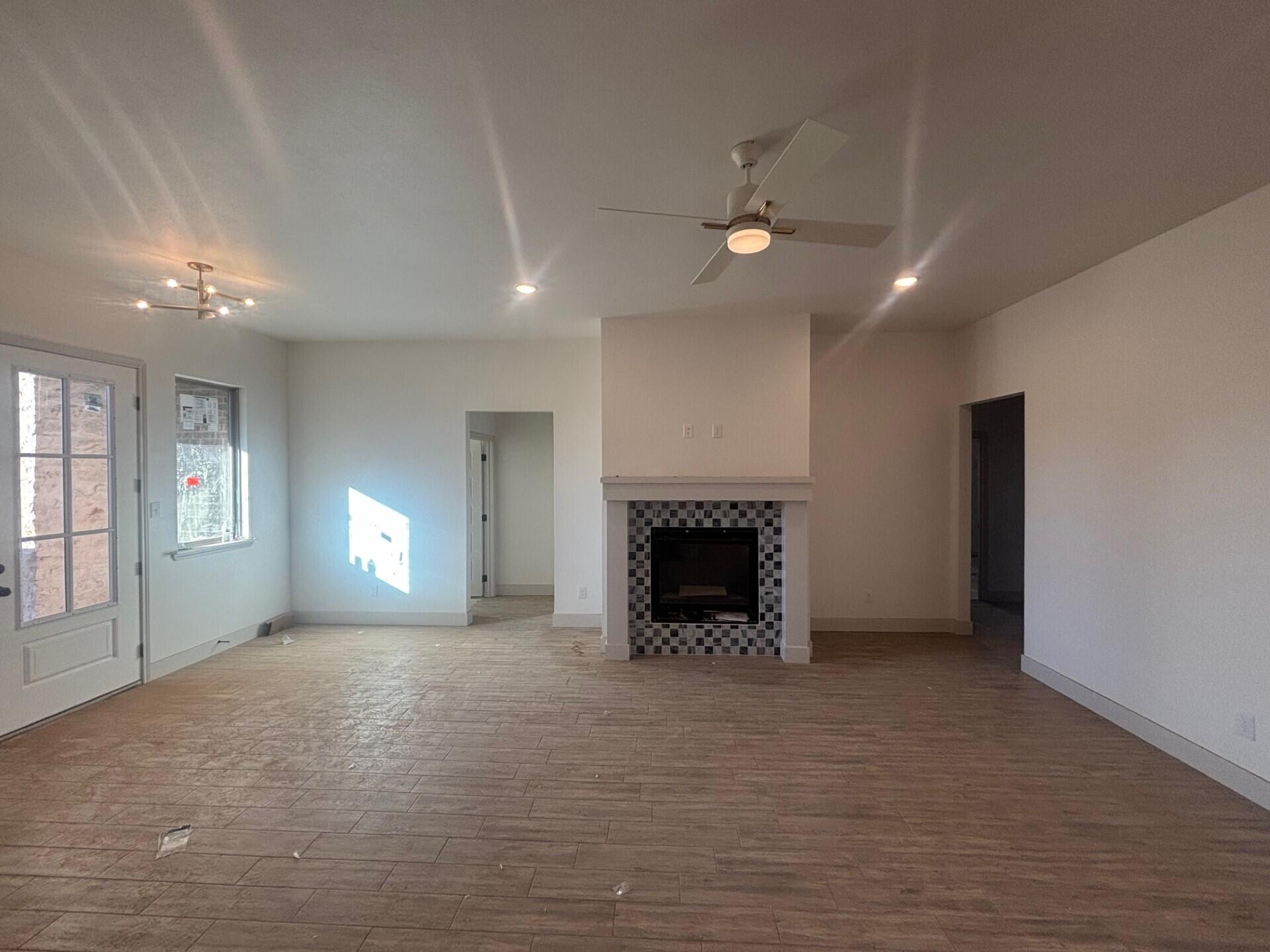 3616 119th Street Lubbock, TX 79423 - Photo 3 of 9 an empty room with windows and fireplace