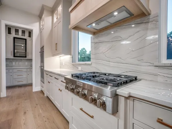 a large kitchen with stainless steel appliances and white cabinets