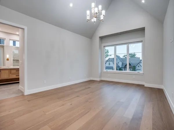 a spacious en suite bathroom with a granite countertop tub double vanity and a mirror