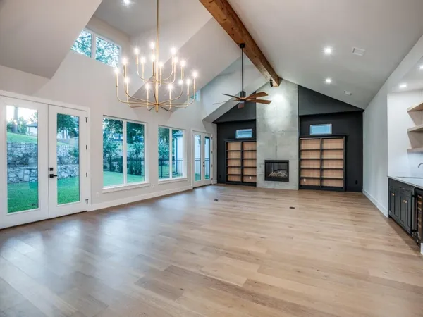a view of a livingroom with wooden floor and a large window