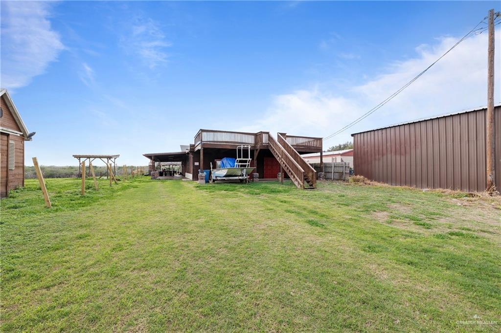 View of yard featuring stairway, a deck, and an outbuilding