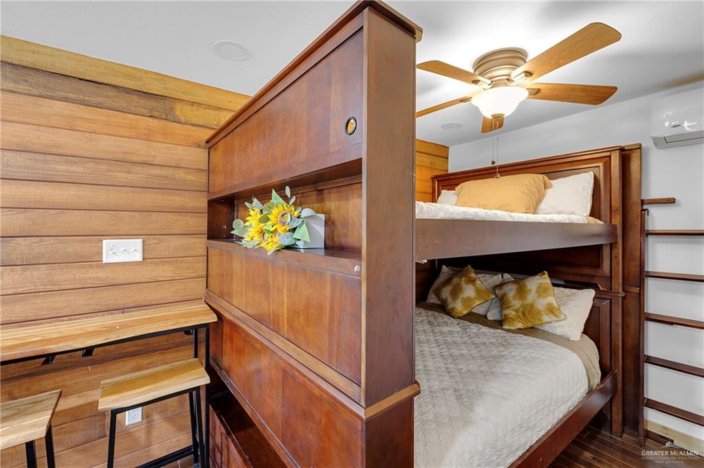 32447 Farm To Market Road 2925 Rio Hondo, TX 78583 - Photo 14 of 25 Bedroom featuring a wall unit AC and dark wood finished floors